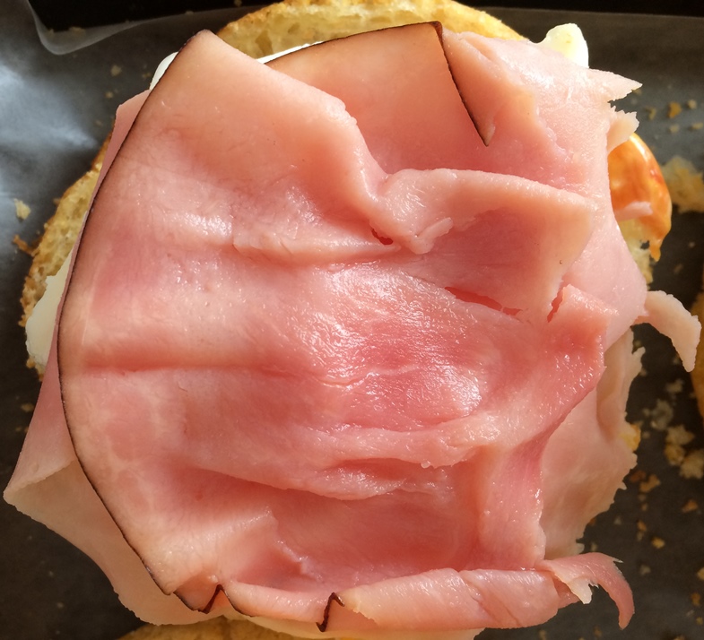 Photo of a glutino gluten free english muffin with ham on top. 